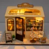 Miniature DIY bakery house kit with warm lighting, tiny pastries, shelves and cozy bakery decor