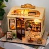 Miniature DIY bakery house kit with warm lighting, tiny pastries, shelves and cozy bakery decor