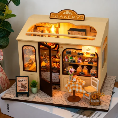 Miniature DIY bakery house kit with warm lighting, tiny pastries, shelves and cozy bakery decor