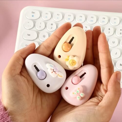 Cute mini cutter with pastel kawaii design held in hand beside a white keyboard