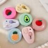 Cute mini cutter with pastel kawaii design held in hand beside a white keyboard