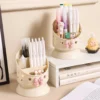 Cute desk organizer with pink bow and star cutouts holding pens and makeup brushes Cute desk organizer with pink bow and star cutouts holding pens and makeup brushes